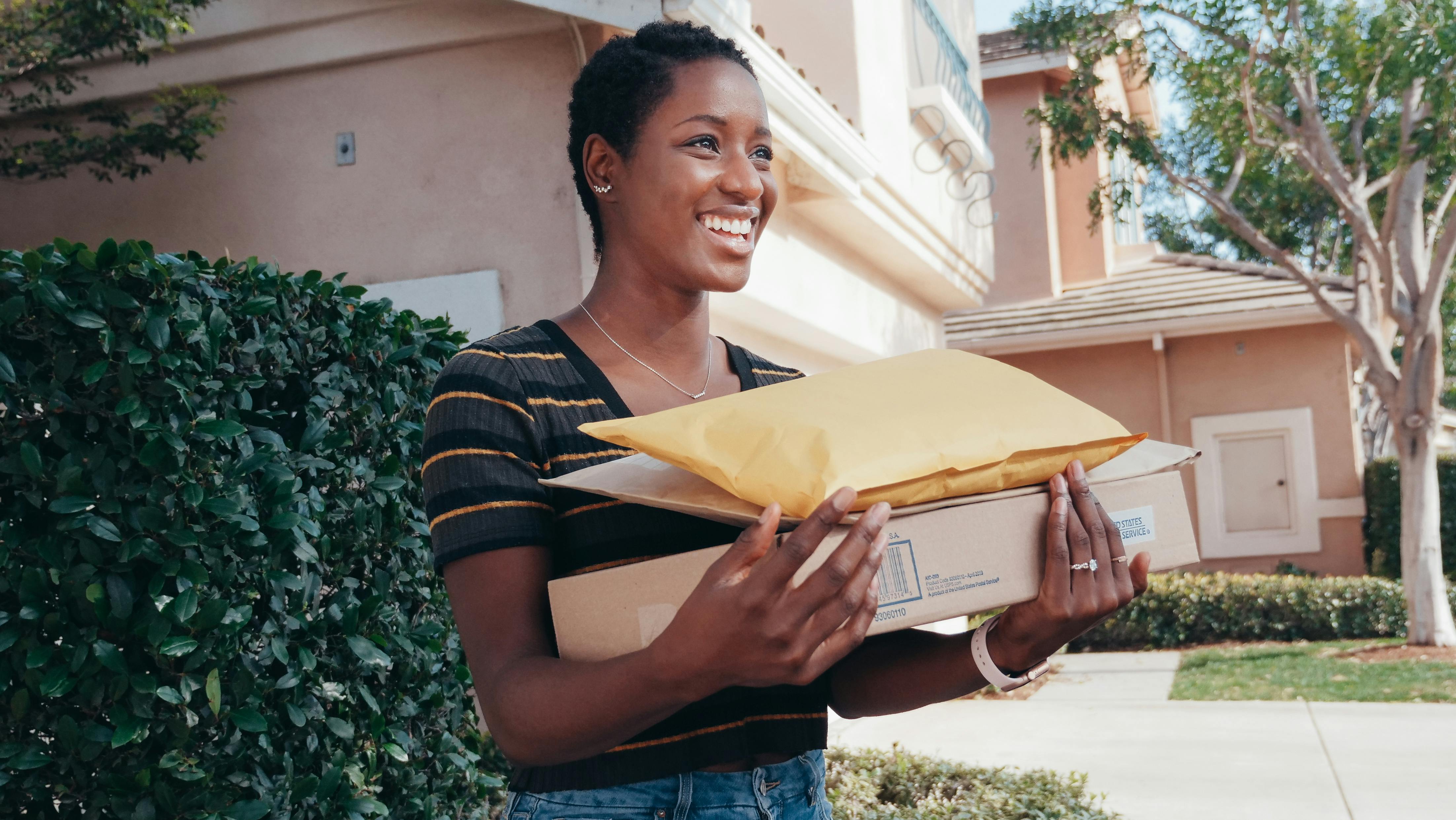 Residential parcel handoff with stacked delivery boxes.