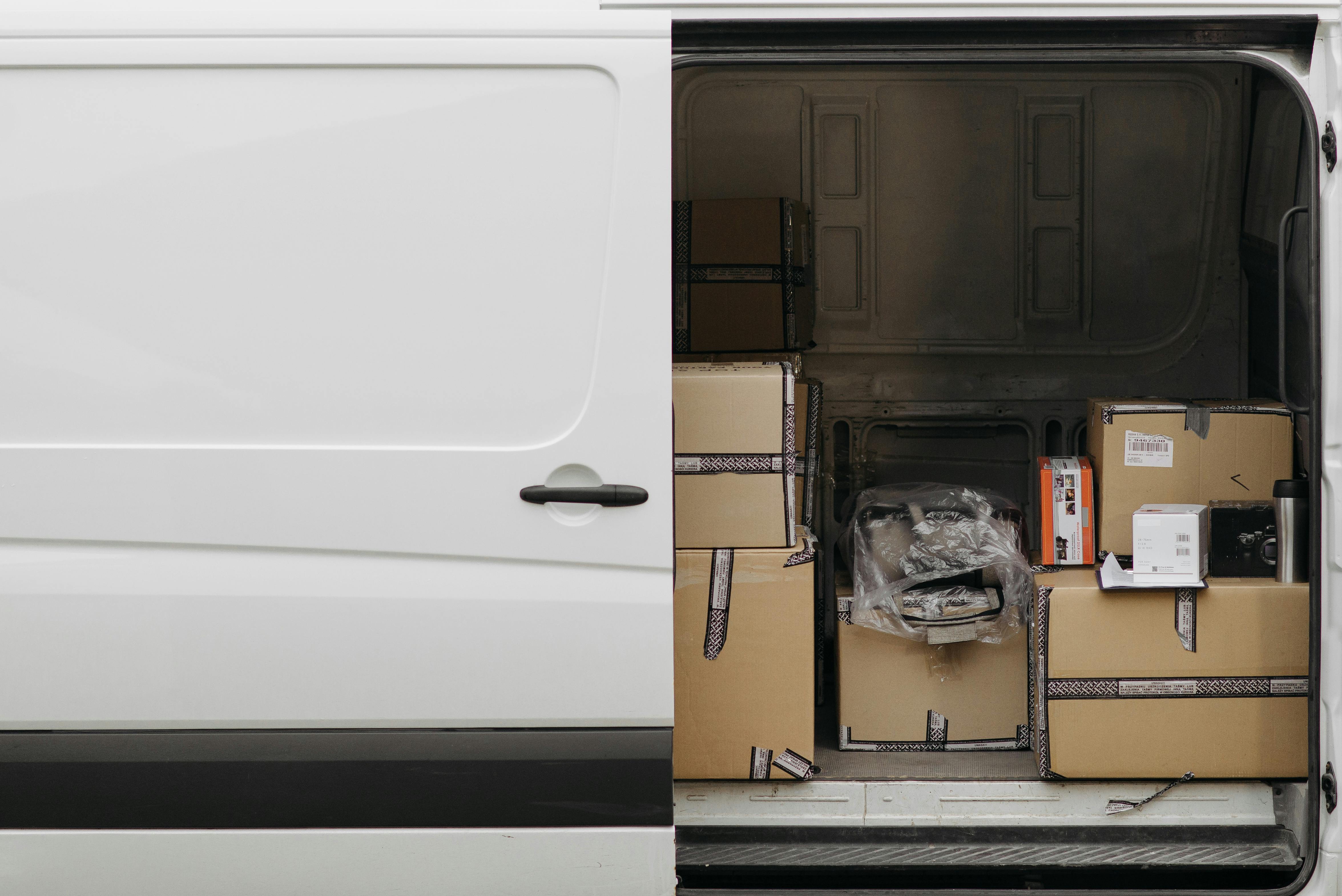 Delivery van with open side door revealing boxes staged for distribution.