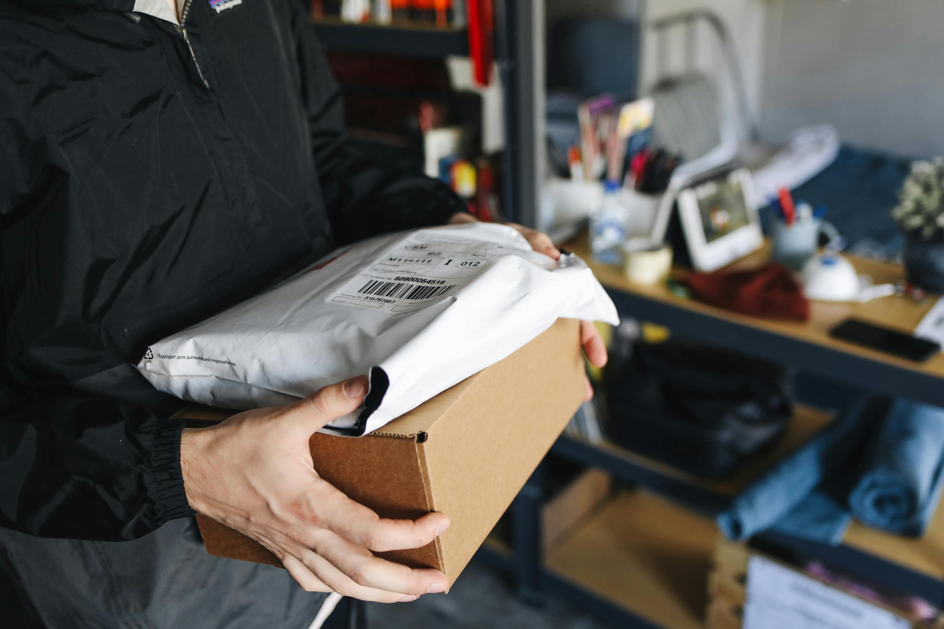 Warehouse worker carrying parcels prepared for outgoing shipment.